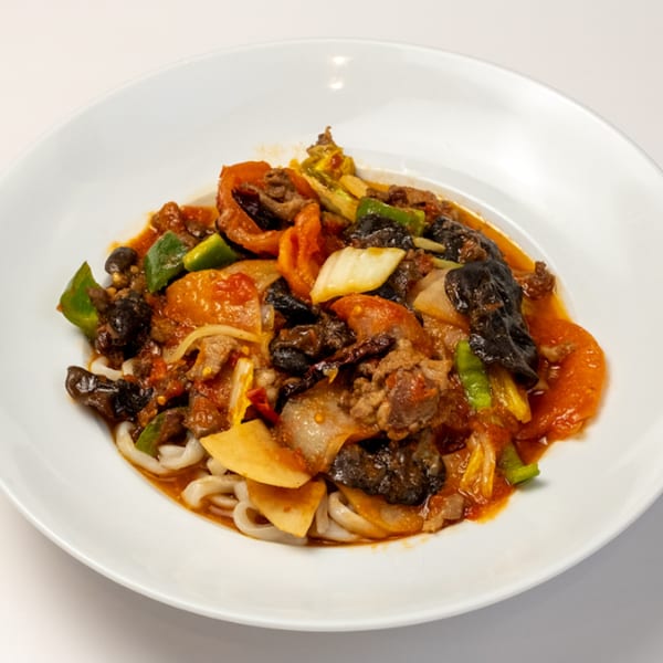 Halal Kusan Collective stir-fried noodles with beef, vegetables, and mushrooms in a rich sauce.