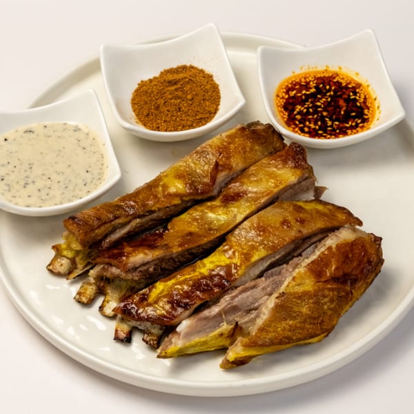 Halal lamb ribs with three dipping sauces: a creamy sauce, a spice blend, and chili oil.