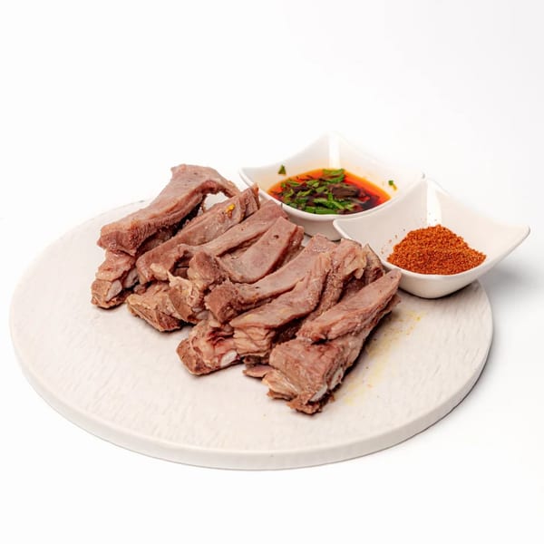 Sliced halal lamb ribs with two dipping sauces, one chili oil and one red spice powder.